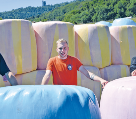 Devant les balles de fourrage colorées, c’est un trio d’agriculteurs Michaël, Bryan et Jean-Pierre Philipona (de g. à dr.), très motivés, qui portent haut les couleurs de la prévention contre le cancer. MMS
