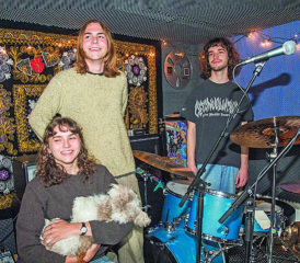 Dans leur local de répétition à Sorens, Amelia Kamber, son frère Alexander (au centre) et leur ami Jonathan Gay évoquent leurs projets et leurs ambitions, sous le regard de leur mascotte Geoffrey. RÉGINE GAPANY