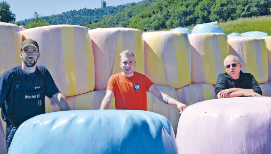 Devant les balles de fourrage colorées, c’est un trio d’agriculteurs Michaël, Bryan et Jean-Pierre Philipona (de g. à dr.), très motivés, qui portent haut les couleurs de la prévention contre le cancer. MMS