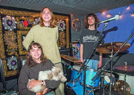 Dans leur local de répétition à Sorens, Amelia Kamber, son frère Alexander (au centre) et leur ami Jonathan Gay évoquent leurs projets et leurs ambitions, sous le regard de leur mascotte Geoffrey. RÉGINE GAPANY