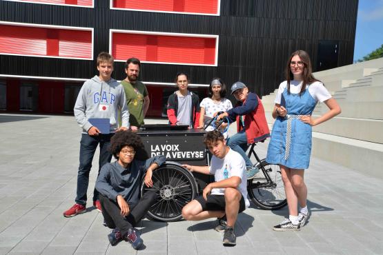 A bord de leur triporteur, des élèves du CO de la Veveyse accueillent les visiteurs de la Méjon Friboua, le village fribourgeois, qui s’est installé à Vevey pendant la Fête des vignerons. VJ